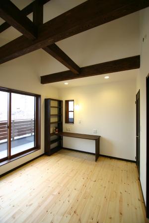 梁、造作カウンター等の色をダーク色に仕上げ、勾配天井の個性ある大人な空間にした寝室。